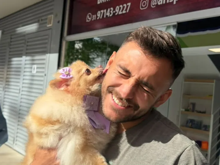 Tutor com seu pet no colo em frente à Aris Pet Spa